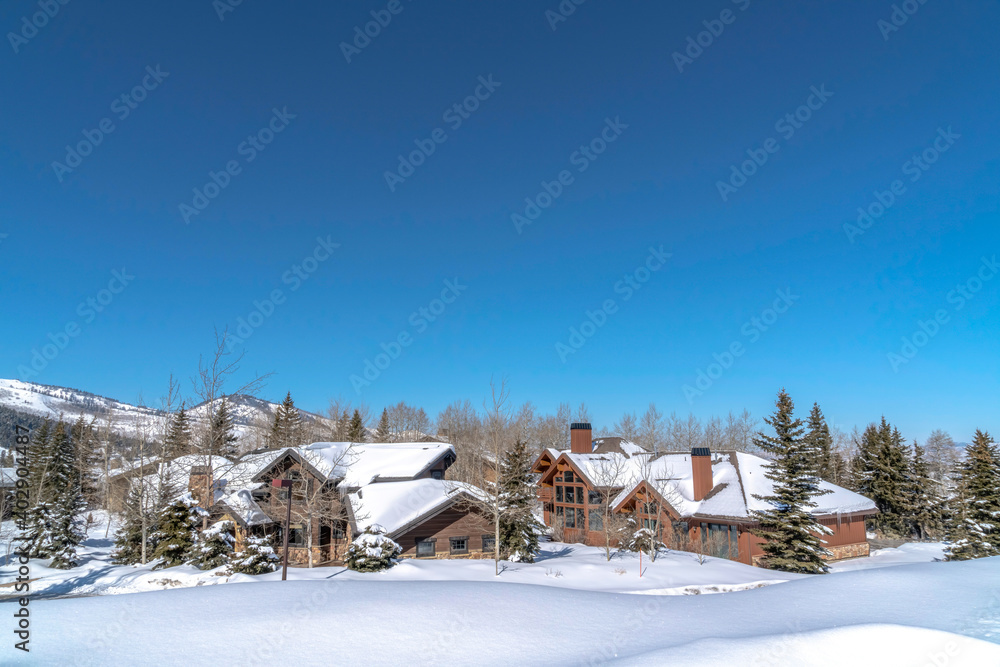 Vivid blue sky over mountain in Park City Utah with homes amid snowy terrain