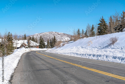 Park City landscape with paved mountain road on a scenic snowy scene in winter