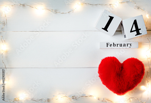 Valentines Day background with red soft heart, garland and wooden block calendar february 14