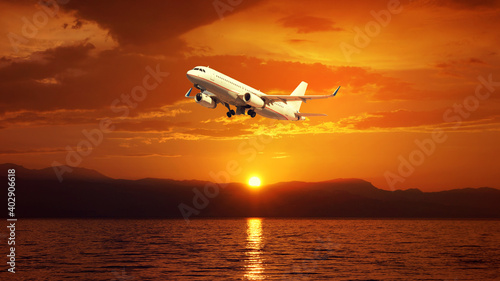 Fototapeta Naklejka Na Ścianę i Meble -  HDR zoom photo of passenger airplane taking off near tropical exotic bay at sunset