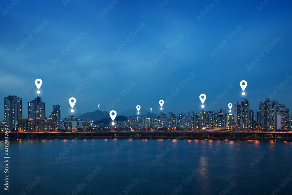 Map pin icons on Seoul cityscape at dusk. Lit residential district and bridge along the Han River in Seoul, South Korea, at night. Copy space.