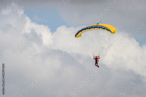 Parasailor glides above lofty clouds