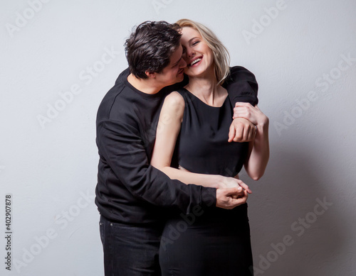 Caucasian heterosexual man and woman in black clothes on white background