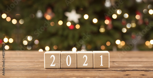 Wooden cube inscription 2021. New Year. Against the background of the Christmas tree