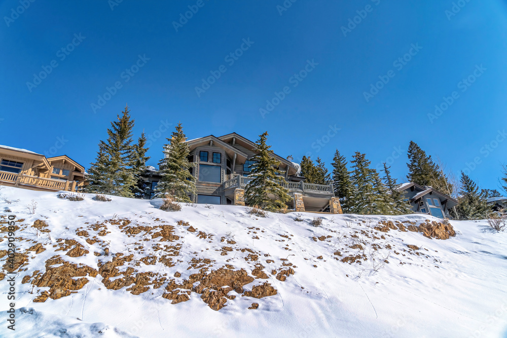 Sunny day view of neighborhood on mountain terrain covered with snow in winter Sunny day view of neighborhood on mountain terrain covered with snow in winter