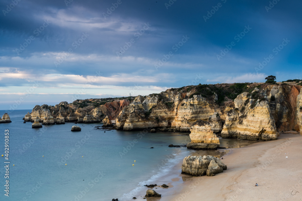 Early morning on the Algarve coast. Famous rocks and calm ocean. Dramatic sky. Lagos, Portugal