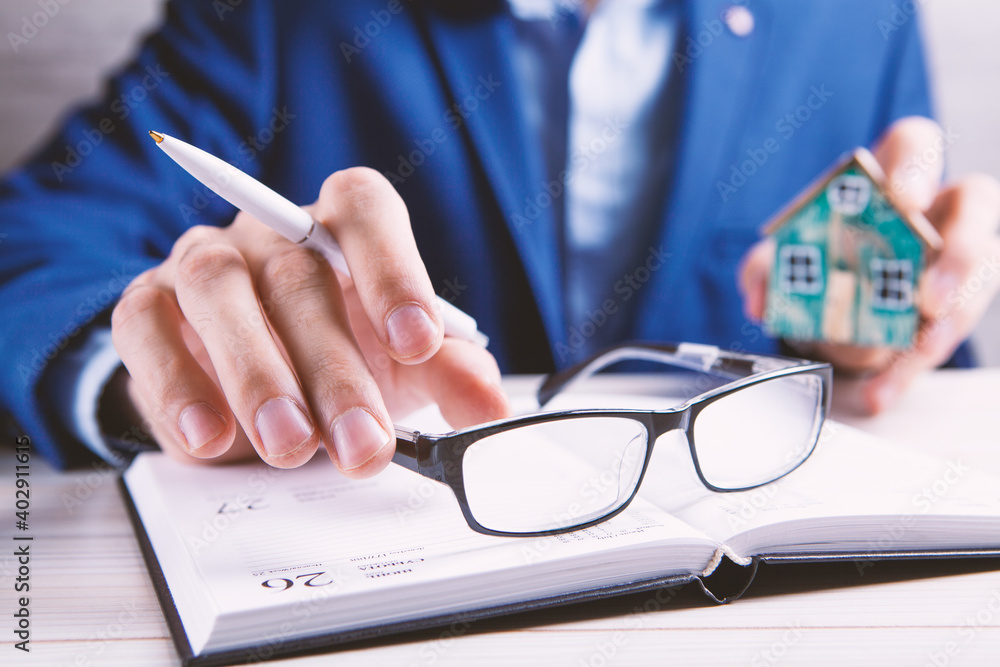 House model with signature of a contract buying or selling a house House model with signature of a contract buying or selling a house