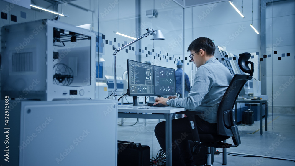 Fototapeta premium Factory Office: Portrait of Beautiful and Confident Male Industrial Engineer Working on Computer, on Screen Industrial Electronics Design Software. High Tech Facility with CNC Machinery