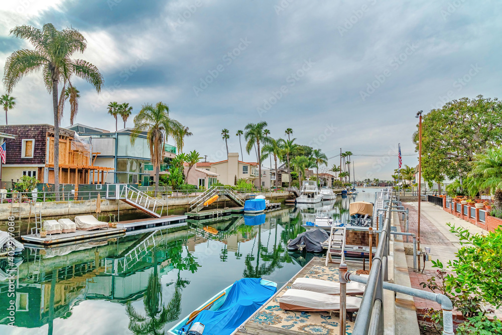 Boats and docks on a canal along homes in Long Beach California on a cloudy day
