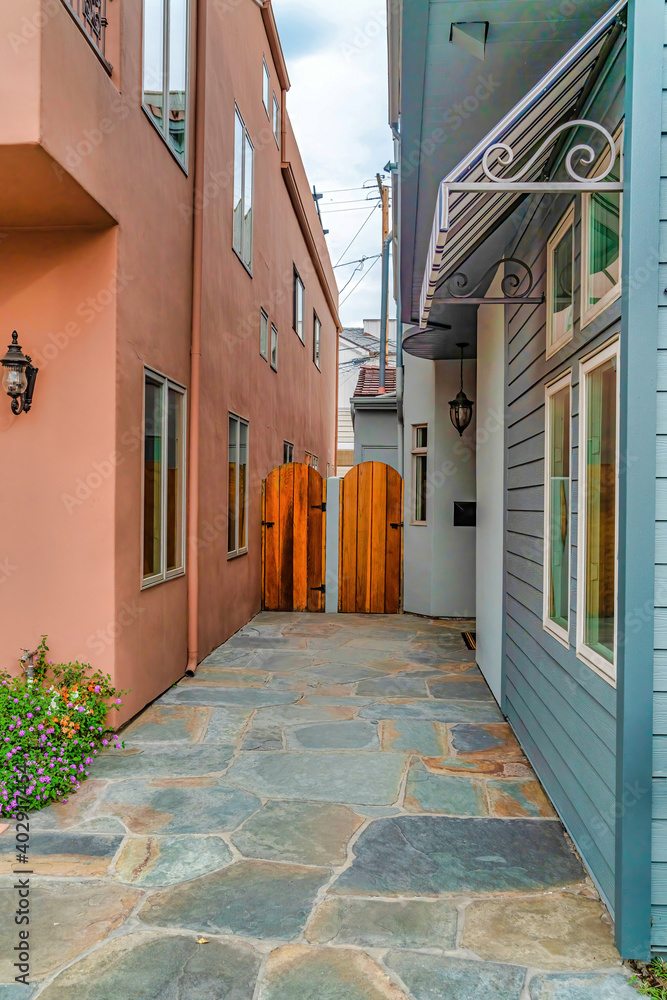 Fototapeta premium Narrow walkway and arched wooden gate between houses in Long Beach California