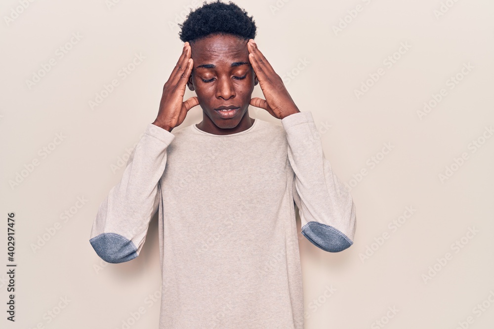 Young african american man wearing casual clothes with hand on head, headache because stress. suffering migraine. Young african american man wearing casual clothes with hand on head, headache because stress. suffering migraine.