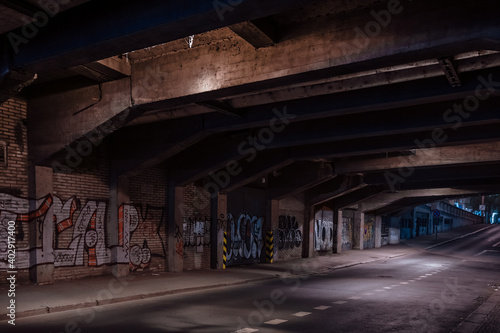 Dark empty dirty grunge underground concrete tunel with a road during mystic night with blue street lights