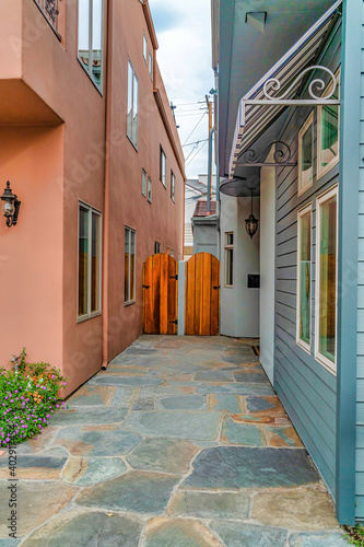 Narrow walkway and arched wooden gate between houses in Long Beach California