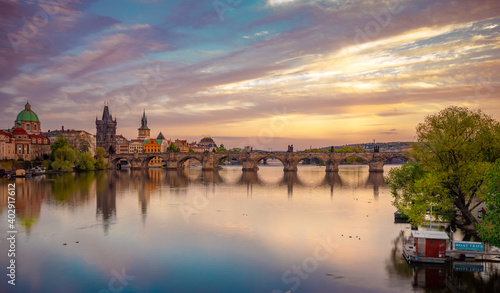 Charles Bridge during beautiful romantic colorful spring summer golden hour before sunset with wonderful blue sky with clouds, Czechia, Europe