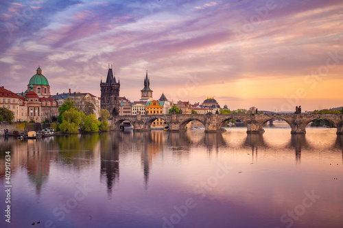 Charles Bridge during beautiful romantic colorful spring summer golden hour before sunset with wonderful blue sky with clouds, Czechia, Europe