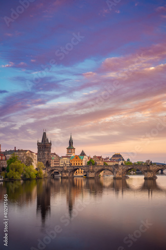 Charles Bridge during beautiful romantic colorful spring summer golden hour before sunset with wonderful blue sky with clouds, Czechia, Europe