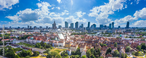 Aerial panorama of Warsaw, Poland over the Vistula river and City center in a distance. Sky Clouds and sun