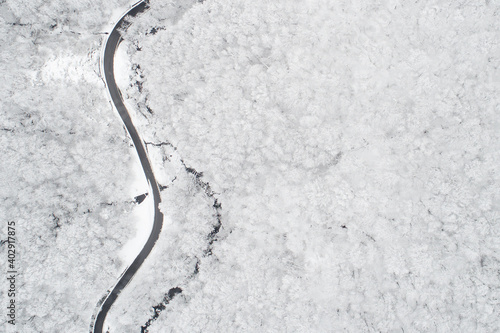 Aerial view of a road in the middle of the white forest © diana