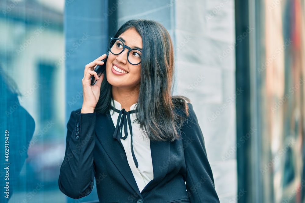 Young hispanic businesswoman smiling happy talking on the smartphone at the city. Young hispanic businesswoman smiling happy talking on the smartphone at the city.