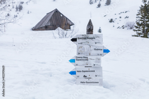 Polskie Tatry, niemal w całości pokryty śniegiem drogowskaz pokazujący kierunki szlaków na Świnicę, Halę Gąsienicową, Kuźnice