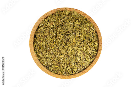 Dried leaves of yerba mate tea in wooden bowl isolated on white background. Nutrition. Traditional tea in South-America.
