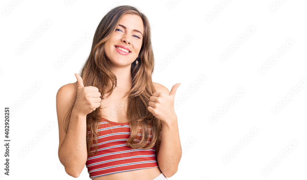 Beautiful caucasian young woman wearing casual clothes success sign doing positive gesture with hand, thumbs up smiling and happy. cheerful expression and winner gesture.