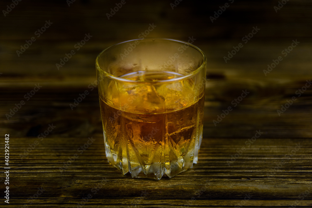 Glass of whiskey on the dark wooden background Glass of whiskey on the dark wooden background