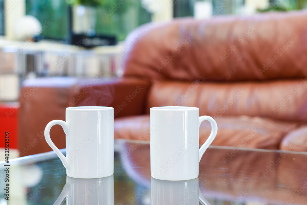Two cups of tea or coffee together on a coffee table in a light home interior room Two cups of tea or coffee together on a coffee table in a light home interior room
