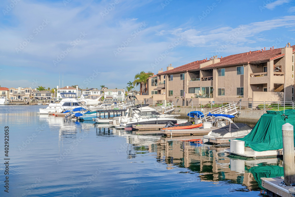 Boats docked at the harbour with waterfront homes in Huntington Beach California