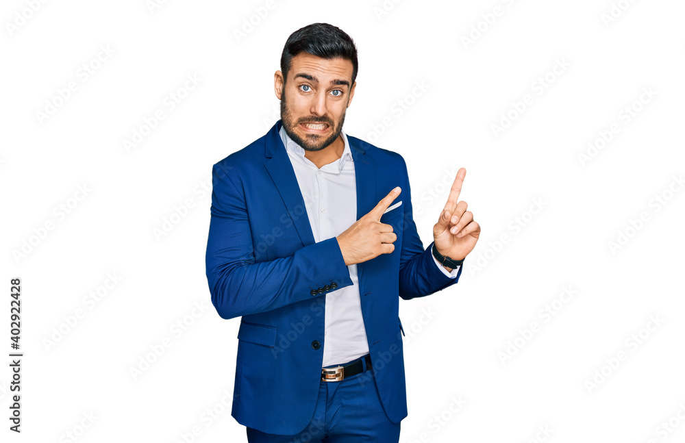 Young hispanic man wearing business jacket pointing aside worried and nervous with both hands, concerned and surprised expression Young hispanic man wearing business jacket pointing aside worried and nervous with both hands, concerned and surprised expression