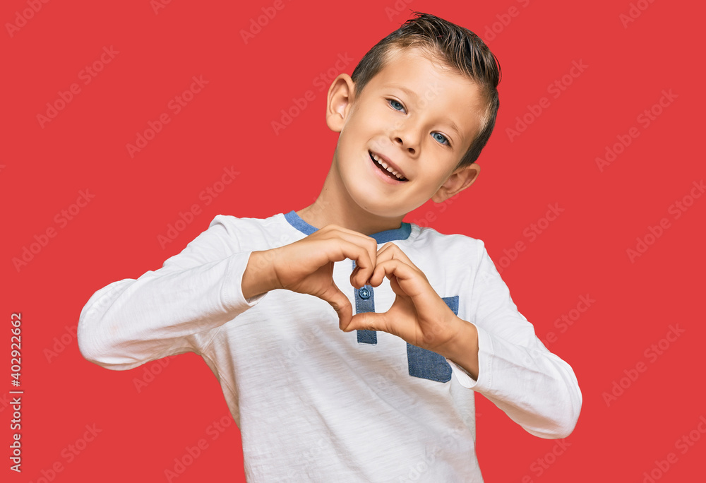 Adorable caucasian kid wearing casual clothes smiling in love doing heart symbol shape with hands. romantic concept. Adorable caucasian kid wearing casual clothes smiling in love doing heart symbol shape with hands. romantic concept.