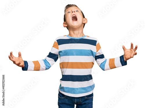 Adorable caucasian kid wearing casual clothes crazy and mad shouting and yelling with aggressive expression and arms raised. frustration concept.