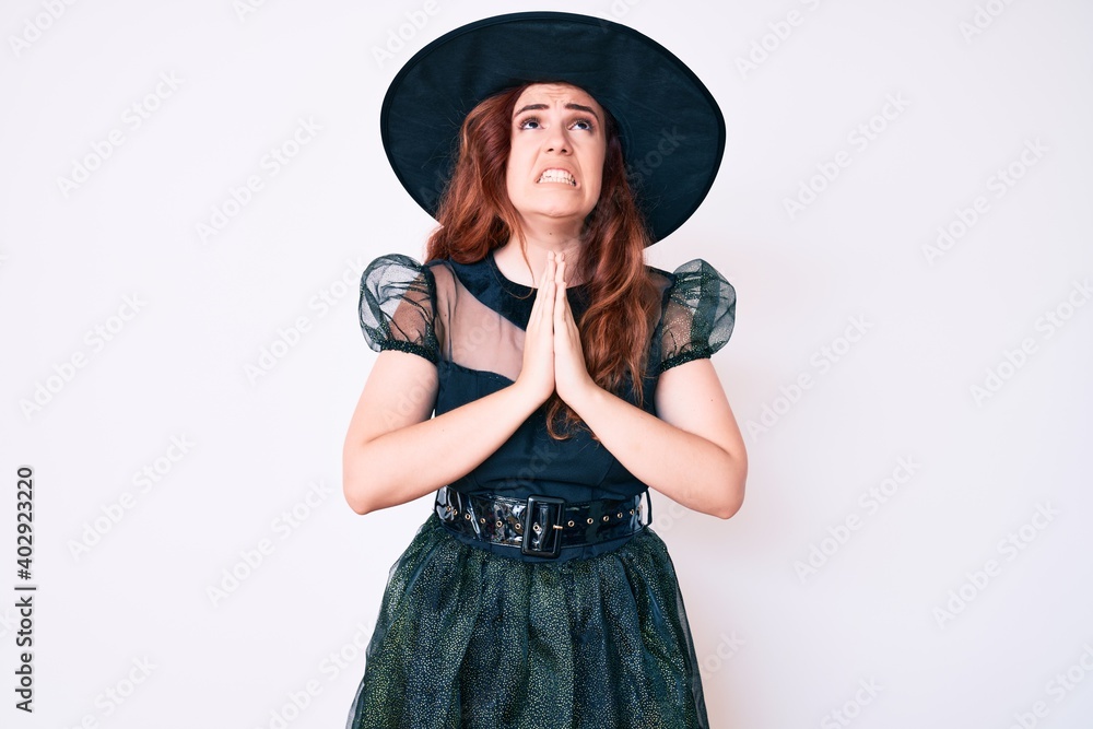 Young beautiful woman wearing witch halloween costume begging and praying with hands together with hope expression on face very emotional and worried. begging. Young beautiful woman wearing witch halloween costume begging and praying with hands together with hope expression on face very emotional and worried. begging.