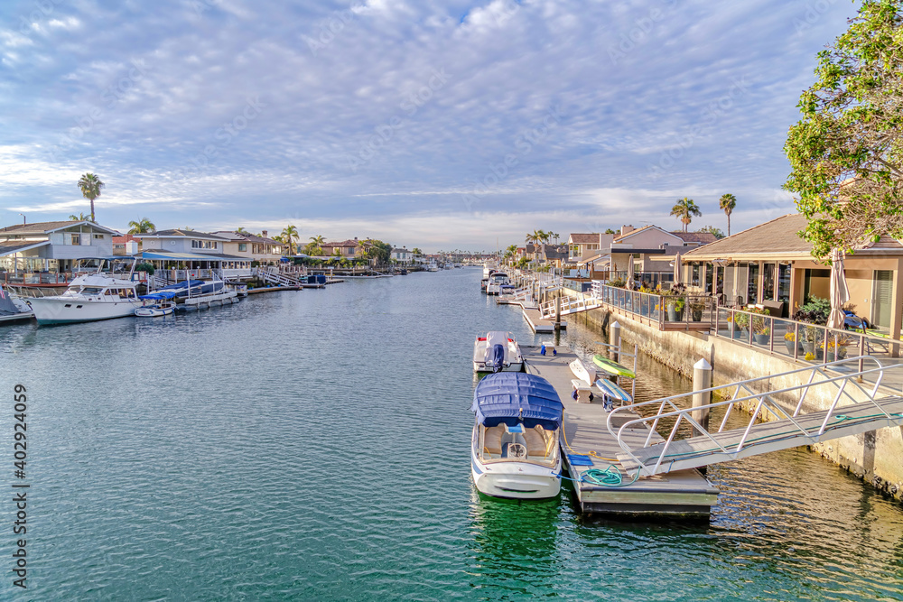 Waterfront homes with boats and private docks overlooking the sea at sunset