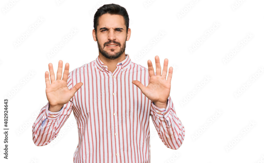 Naklejka premium Young hispanic man wearing business shirt afraid and terrified with fear expression stop gesture with hands, shouting in shock. panic concept.