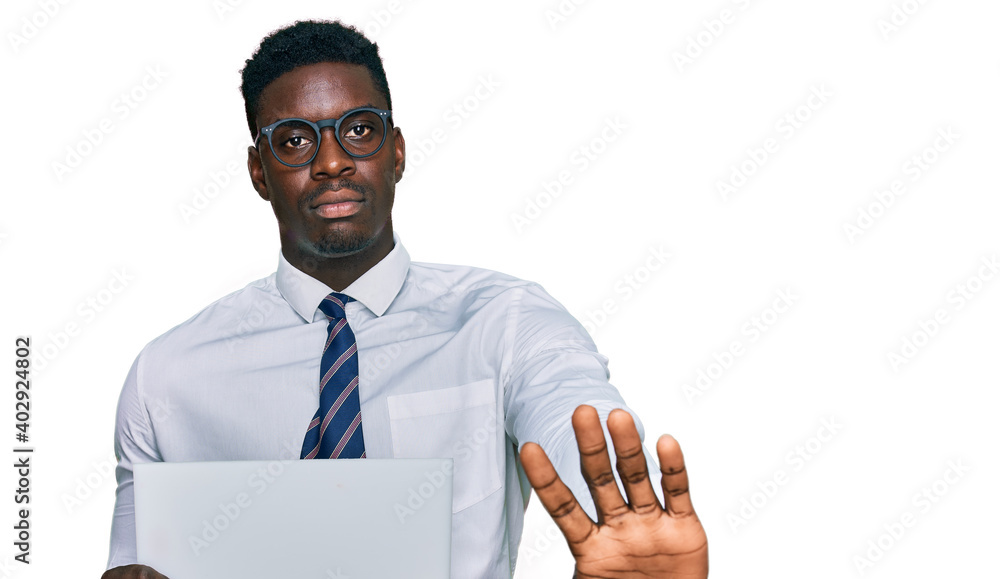 Handsome business black man holding blank empty banner with open hand doing stop sign with serious and confident expression, defense gesture Handsome business black man holding blank empty banner with open hand doing stop sign with serious and confident expression, defense gesture