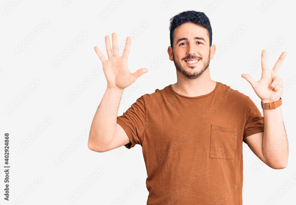 Young hispanic man wearing casual clothes showing and pointing up with fingers number eight while smiling confident and happy. Young hispanic man wearing casual clothes showing and pointing up with fingers number eight while smiling confident and happy.