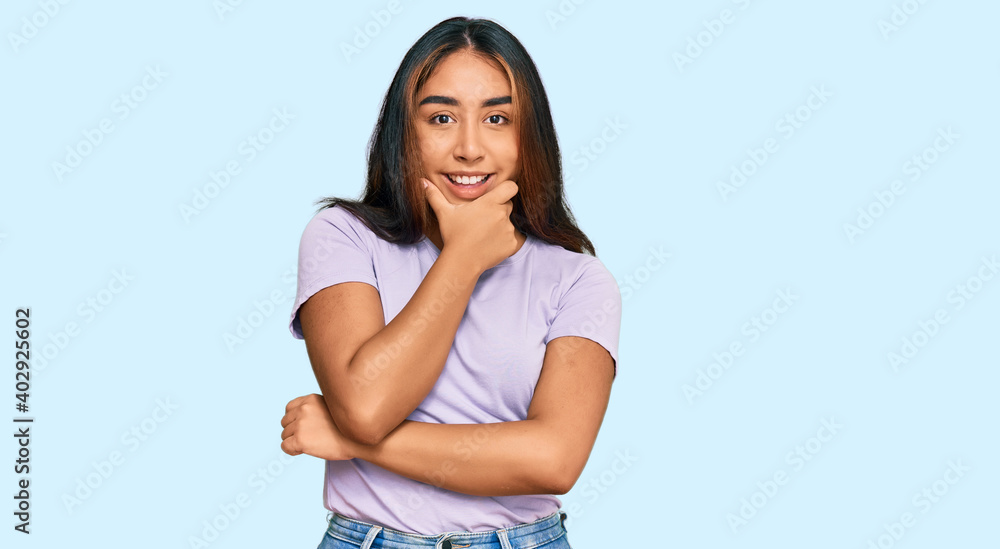 Young latin woman wearing casual clothes looking confident at the camera smiling with crossed arms and hand raised on chin. thinking positive.