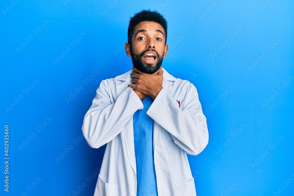 Handsome hispanic man with beard wearing doctor uniform shouting and suffocate because painful strangle. health problem. asphyxiate and suicide concept. Handsome hispanic man with beard wearing doctor uniform shouting and suffocate because painful strangle. health problem. asphyxiate and suicide concept.
