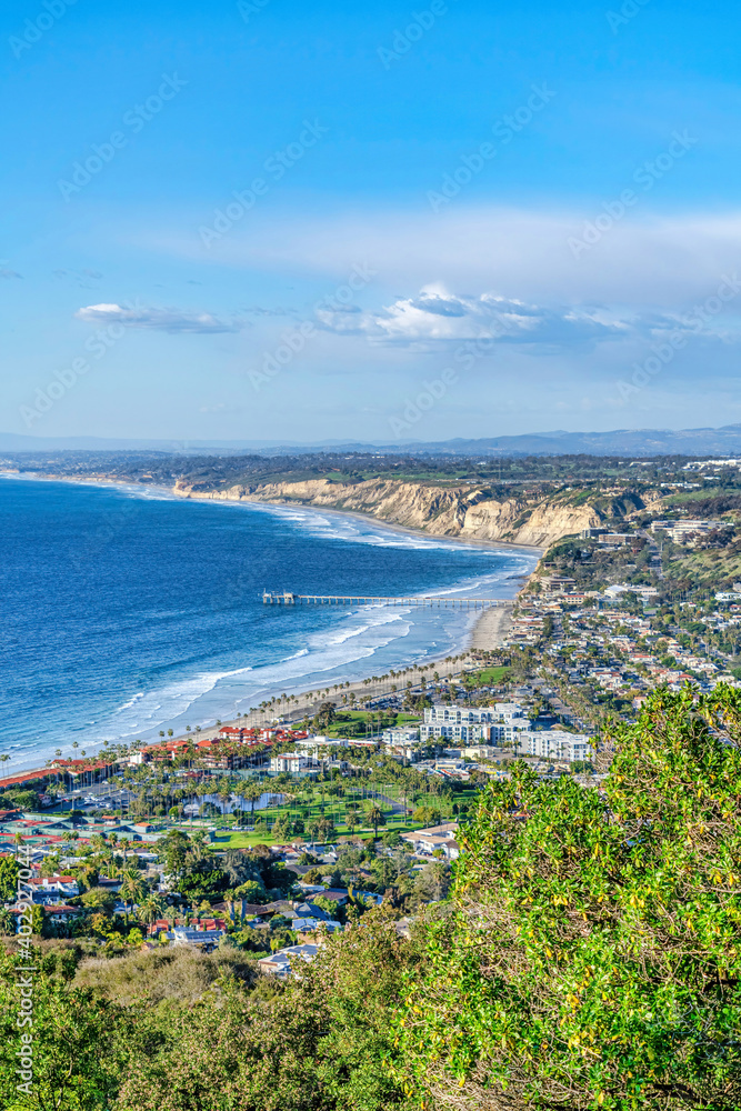 Fototapeta premium San Diego California coast bordered by scenic blue ocean against vast cloudy sky