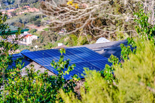 Solar panels on the roof of house in San Diego California against green foliage