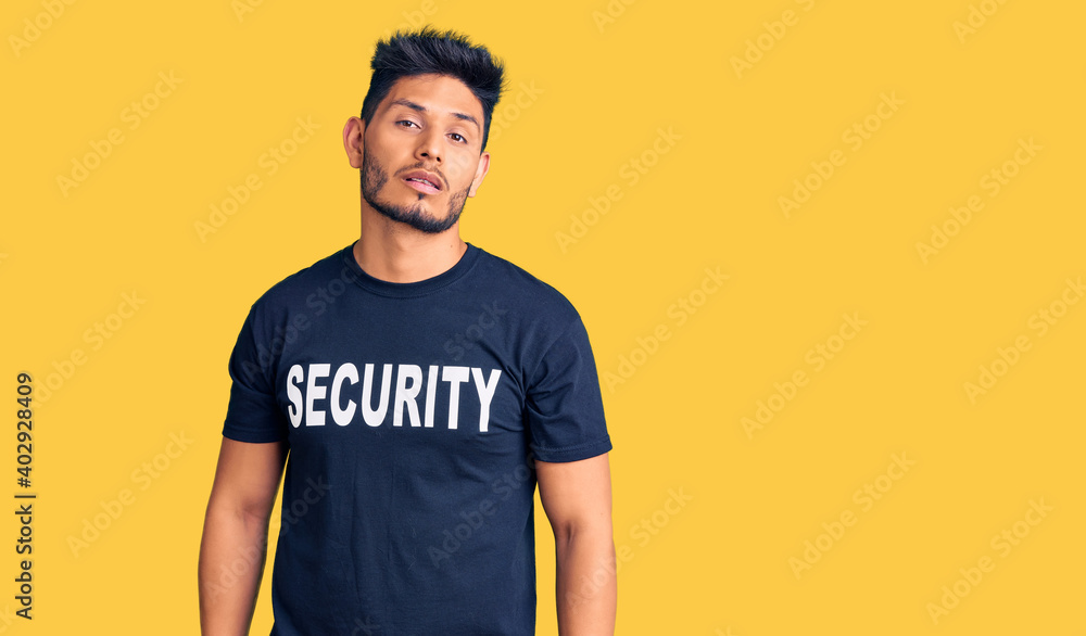 Handsome latin american young man wearing security t shirt looking sleepy and tired, exhausted for fatigue and hangover, lazy eyes in the morning. Handsome latin american young man wearing security t shirt looking sleepy and tired, exhausted for fatigue and hangover, lazy eyes in the morning.