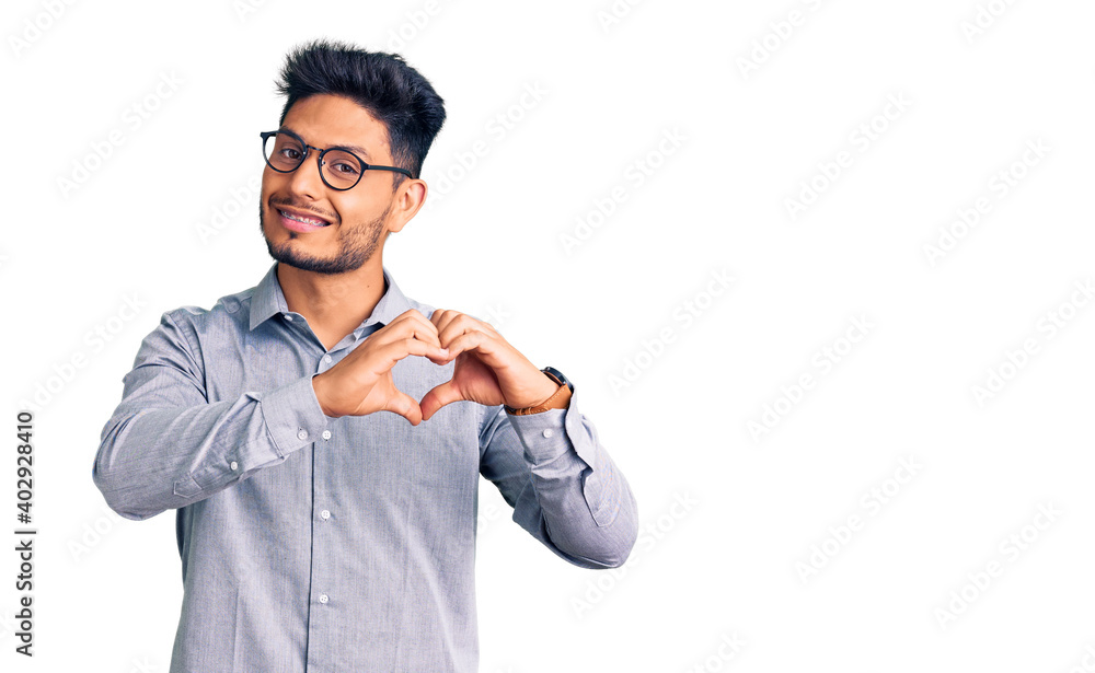 Handsome latin american young man wearing business clothes and glasses smiling in love showing heart symbol and shape with hands. romantic concept. Handsome latin american young man wearing business clothes and glasses smiling in love showing heart symbol and shape with hands. romantic concept.