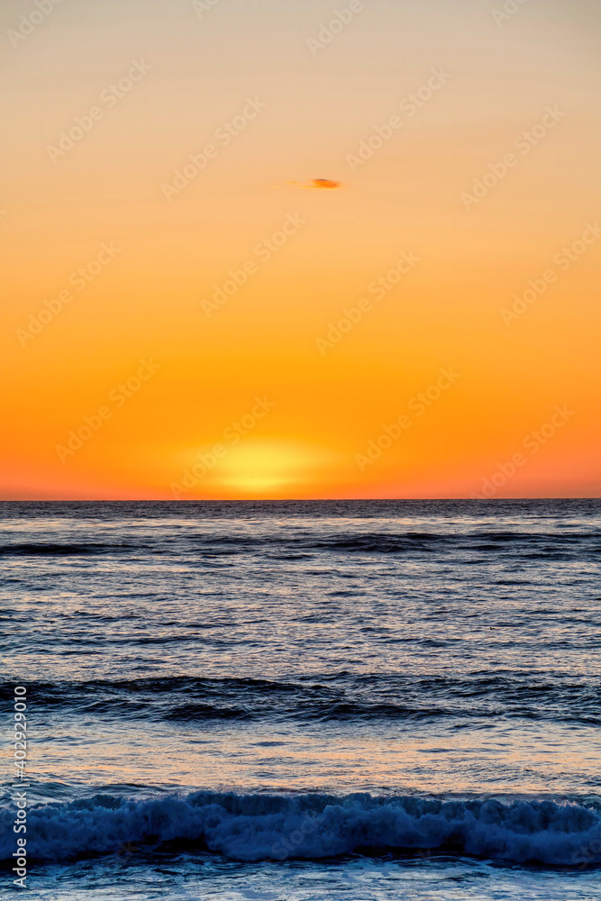 Dark ocean and orange sky at the horizon during sunset at San Diego California