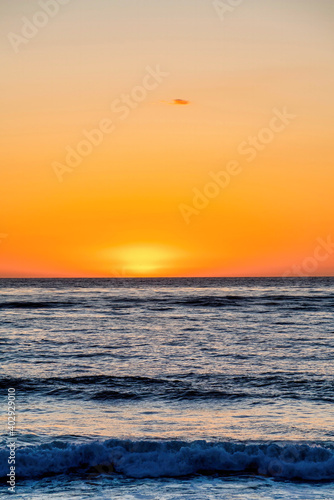 Dark ocean and orange sky at the horizon during sunset at San Diego California © Jason