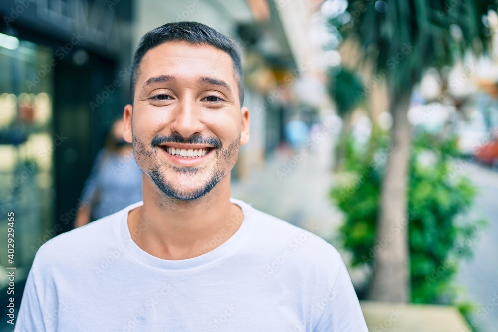 Young hispanic man smiling happy walking at street of city. Young hispanic man smiling happy walking at street of city.