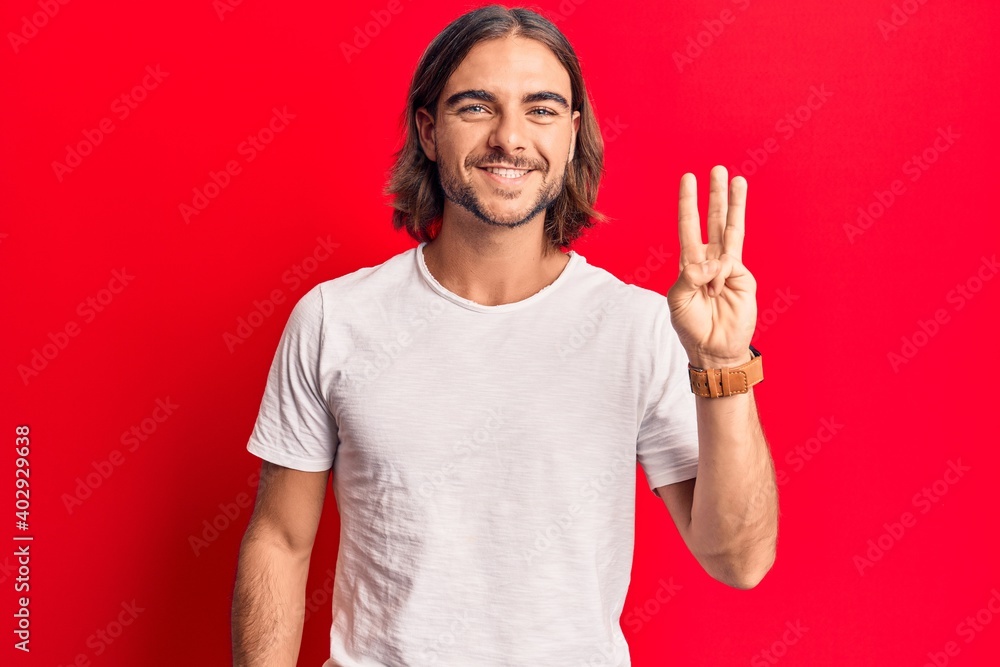 Naklejka premium Young handsome man wearing casual clothes showing and pointing up with fingers number three while smiling confident and happy.