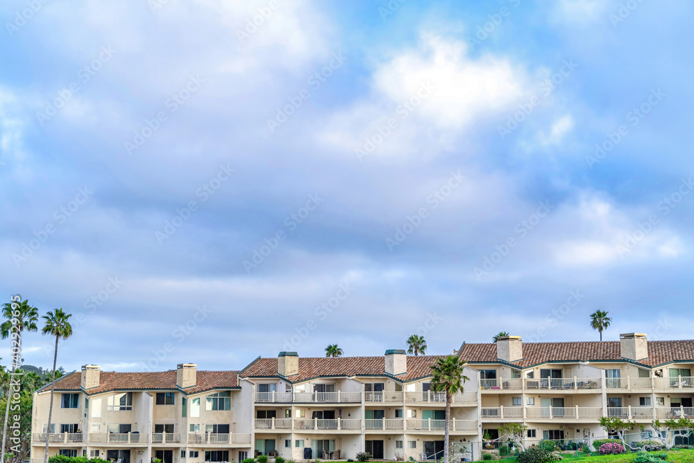 Facade of residential building in San Diego California with clouds and blue sky