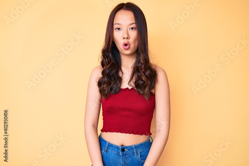 Young beautiful chinese girl wearing summer clothes scared and amazed with open mouth for surprise, disbelief face