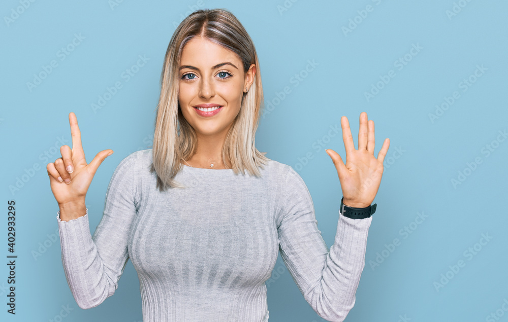 Beautiful blonde woman wearing casual clothes showing and pointing up with fingers number seven while smiling confident and happy. Beautiful blonde woman wearing casual clothes showing and pointing up with fingers number seven while smiling confident and happy.